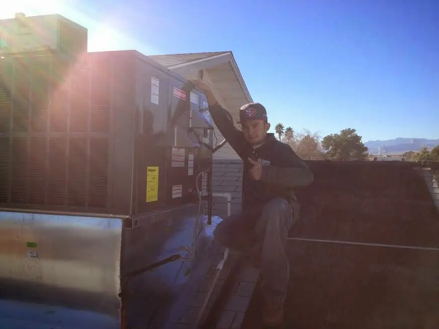 HVAC technician performing Air Duct Cleaning on a rooftop unit in Bremerton